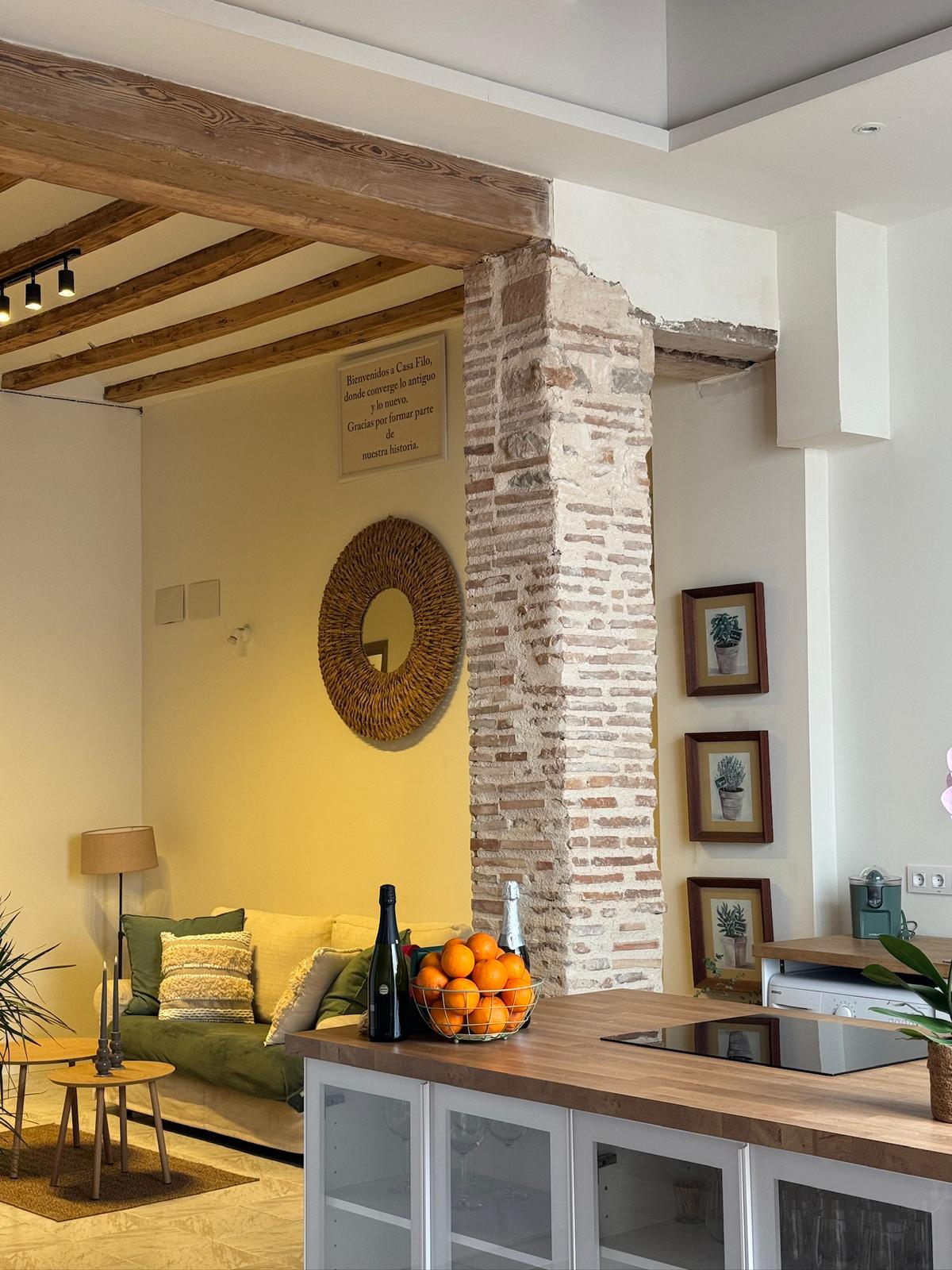 Salón visto desde la cocina con columna de ladrillo - Casa rural Xeresa