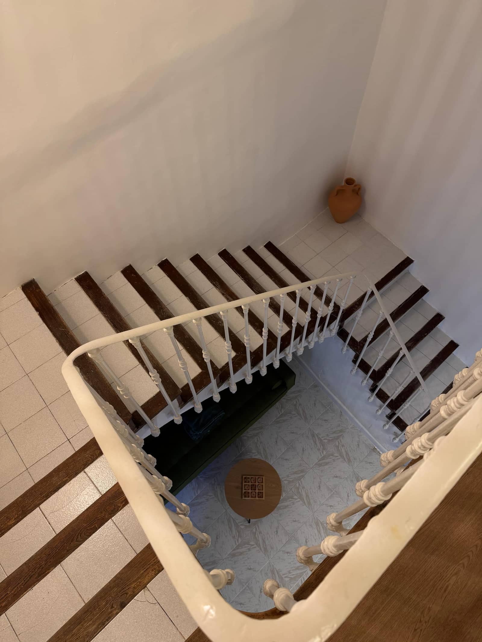 Escalera tradicional con peldaños de madera y barandilla blanca - Casa Filo